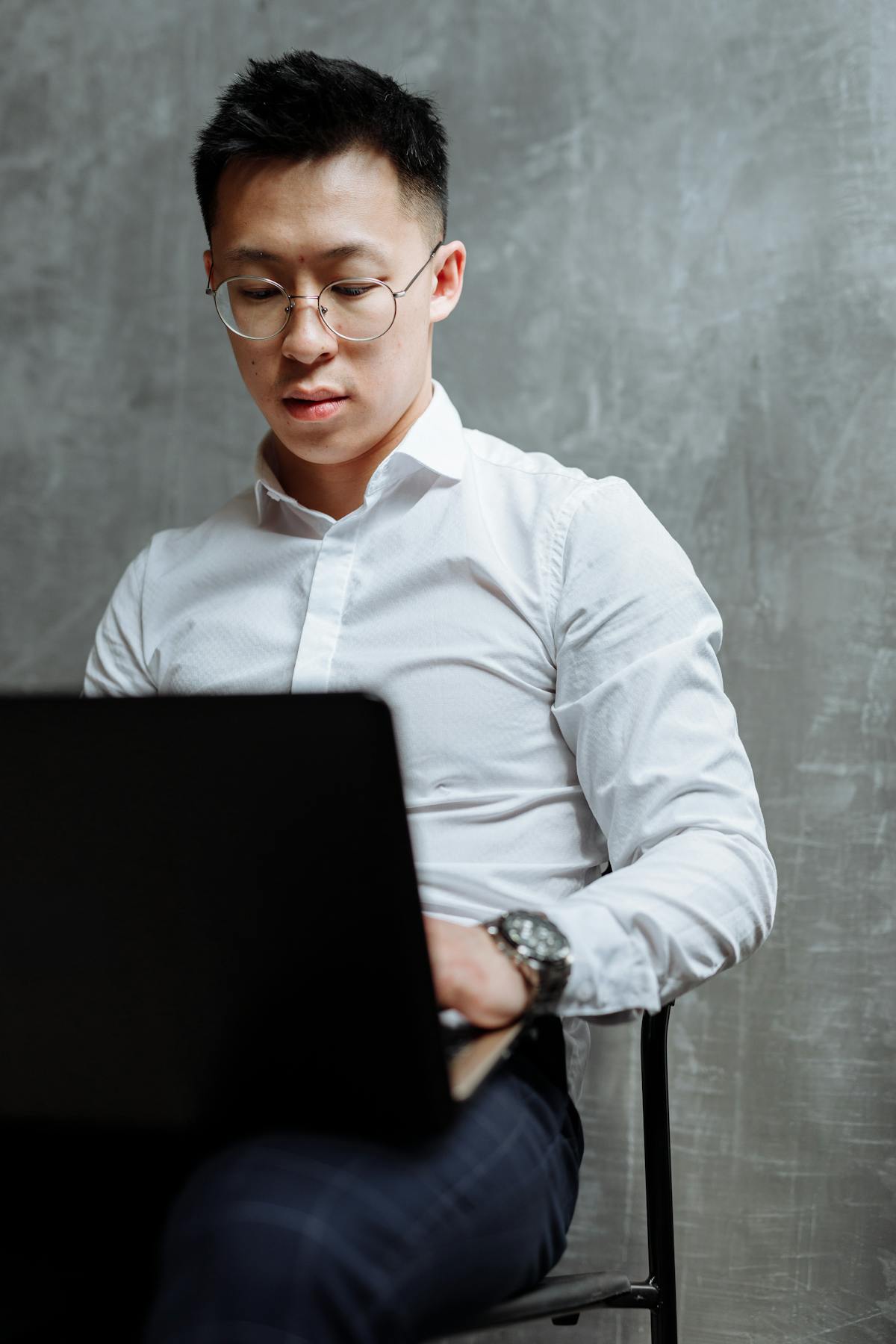 Homem estudando em notebook com livros e anotações ao lado